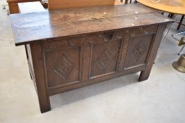 A period oak kist having carved frieze and three carved panels, dimensions approx. W140 H73 D54cm