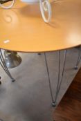 A vintage style circular kitchen table having stylised chrome legs, diameter approx. 90cm