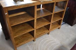 A modern hardwood and composite stone shelving unit, the top having three inset composite stone