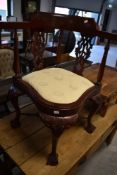 A reproduction mahogany corner chair, in the Victorian style with carved and pierced decoration,