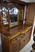 An early 20th century oak mirror back sideboard, the raised back with three arched mirrored panels