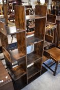A modern stained/burned wood effect open display stand, with thirteen open shelves, 140cm