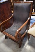 A Colonial or Regency style mahogany armchair with padded one-piece back and seat between