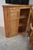 A stripped pine corner cupboard
