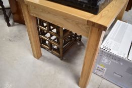 A modern light hard wood extending dining table with integral folding leaf housed to the