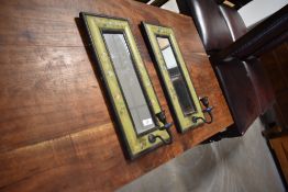 A pair of decorative mirrored wall sconces, of oblong form, the cushion moulded frames painted