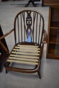 An Ercol cottage armchair having hoop and stick back with fleur de lys