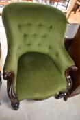 A Victorian button back easy chair having mahogany scroll frame
