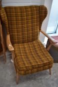 A vintage Ercol or similar wing back armchair with moquette upholstery