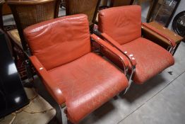 A pair of designer vintage chrome frame and red leather easy chairs