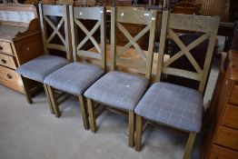 A set of four modern dining chairs having grey tweed style upholstered seats