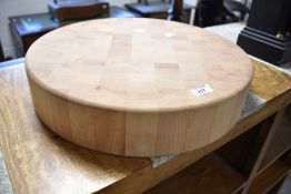 A modern circular butchers style chopping board, constructed from numerous end grain sections and