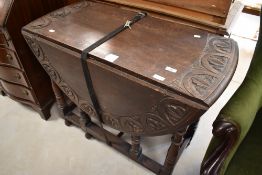 A late 19th or early 20th Century gate leg dining table having lunette carved decoration