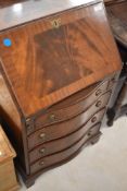 A reproduction mahogany bureau of dwarf form having serpentine front, width approx. 54cm