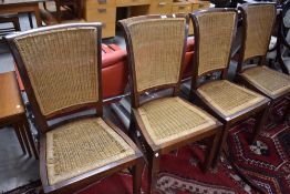 A set of four modern hardwood dining chairs with canework seats and backs