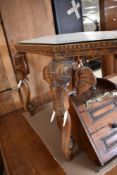 An Eastern style coffee table having canted edge and carved elephants under glass , with elephant
