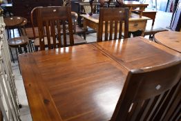 A modern stained hardwood extending dining table and four matching slat back dining chairs 76cm x