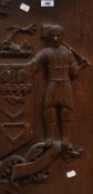 19th/20th Century, a stained oak panel carved in relief with a Yeoman beside heraldic symbols,