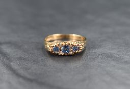 A 9ct gold sapphire and diamond ring, the three round cut graduated sapphires measuring between