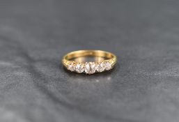 An 18ct gold five stone diamond ring, the graduated old European cut diamonds measuring between