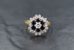 An 18ct gold sapphire and diamond triple daisy cluster ring having central brilliant cut diamond