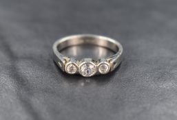 A platinum diamond trilogy ring having three diamonds, total approx 0.6ct in collared mounts to