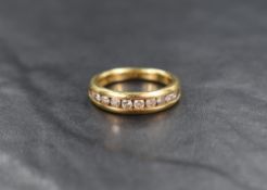 An 18ct gold half eternity ring having ten small brilliant cut diamonds in a channel setting,