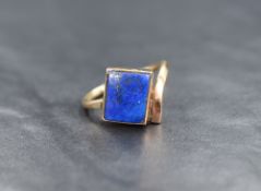 An Artisan style yellow metal ring stamped 9ct having a rectangular lapiz lazuli stone in a closed