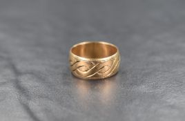 A 9ct gold band, having decorative interweaving ribbon engraving, ring size N-O, 3.6g