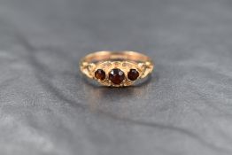 A 9ct gold garnet ring, the three round cut graduated garnets in a openwork setting, having