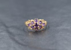 A 9ct gold amethyst cluster ring, the nine round cut amethysts in a floral motif cluster with