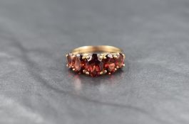 A 9ct gold five stone garnet ring, the graduated oval cut garnets measuring approximately 0.75ct