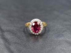 An 18ct gold oval synthetic ruby and diamond chip cluster ring having a claw set raised mount,