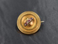 An 18ct gold ruby and diamond brooch, the circular brooch having alternating ruby and diamond