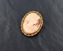 A 9ct gold shell cameo brooch, depicting a maiden in profile in a bezel mount with twisted rope
