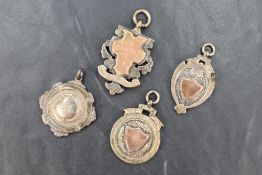 Four silver medallions, two with vacant shield cartouches and two engraved 'C. Goodman Kendal