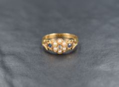 An 18ct gold seed pearl, diamond and sapphire ring, the floral motif ring set with seed pearls and