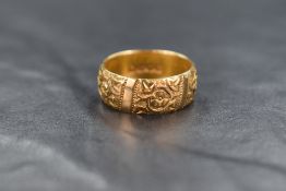 An 18ct gold band, having decorative floral motif panels, ring size O, 7.6g