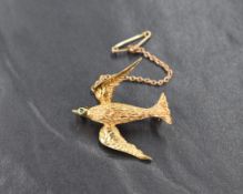 A 14ct gold Grosse of Germany brooch, depicting a bird having textured body and green gem set eye,