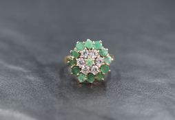 A 9ct gold triple cluster ring having cubic zirconia and emerald style stones in a claw set basket