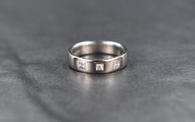A platinum band ring having three inset princess cut diamonds, each stone approx 0.15ct, size I &