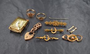 An assortment of gold items, including a 9ct cased wristwatch face, two small 9ct signet rings,