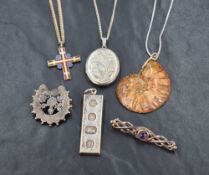 A small selection of silver and white metal jewellery including an oval locket, fossil pendant,