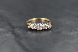 A five stone graduated diamond ring, total approx 1.25ct in a claw set raised mount on a yellow