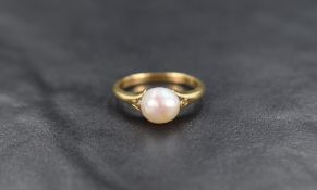 An 18ct gold cultured pearl solitaire ring having split shoulders, ring size G and approximately 2.