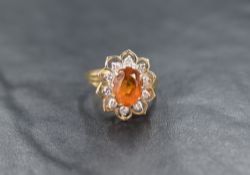 A 14ct gold citrine and diamond cluster ring, the central oval cut citrine with a ten diamond