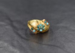 A yellow metal ring of domed form having a small turquiose cabochon posy cluster on a brushed
