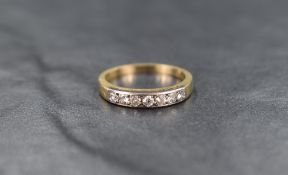 A seven stone diamond eternity ring, total approx 0.35ct in a channel set mount on a yellow metal