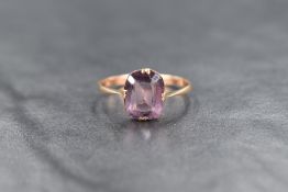 A 9ct gold purple paste ring, the rectangular cut paste in a four claw setting, ring size O, 1.5g.