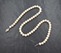 A string of cultured pearls of even form with a silver fish hook clasp, approx 16'